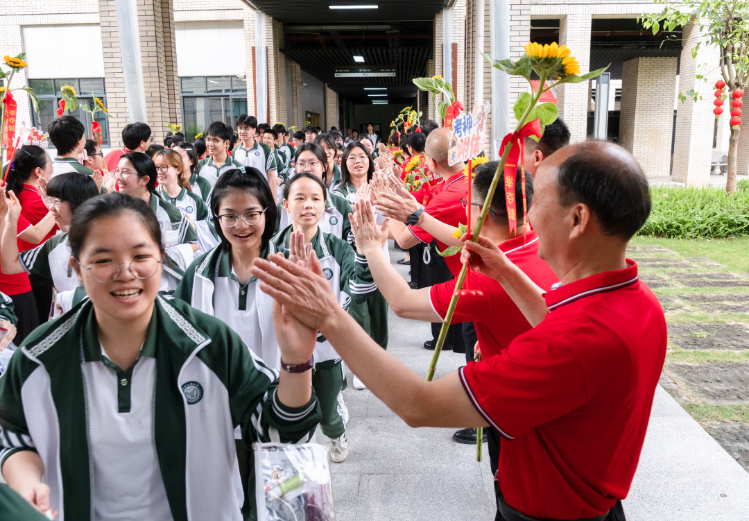 广州市培英中学云城校区考场,老师们人手一支葵花
列队送考,祝福考生“考神附体”“一举夺魁”“旗开得胜”。