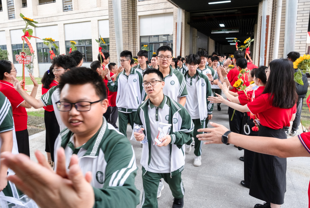 广州市培英中学云城校区考场,老师们人手一支葵花
列队送考,祝福考生“考神附体”“一举夺魁”“旗开得胜”。