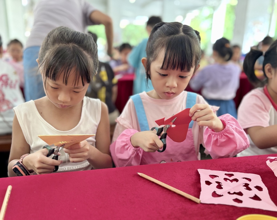 孩子们在开学迎新活动上体验非遗剪纸。