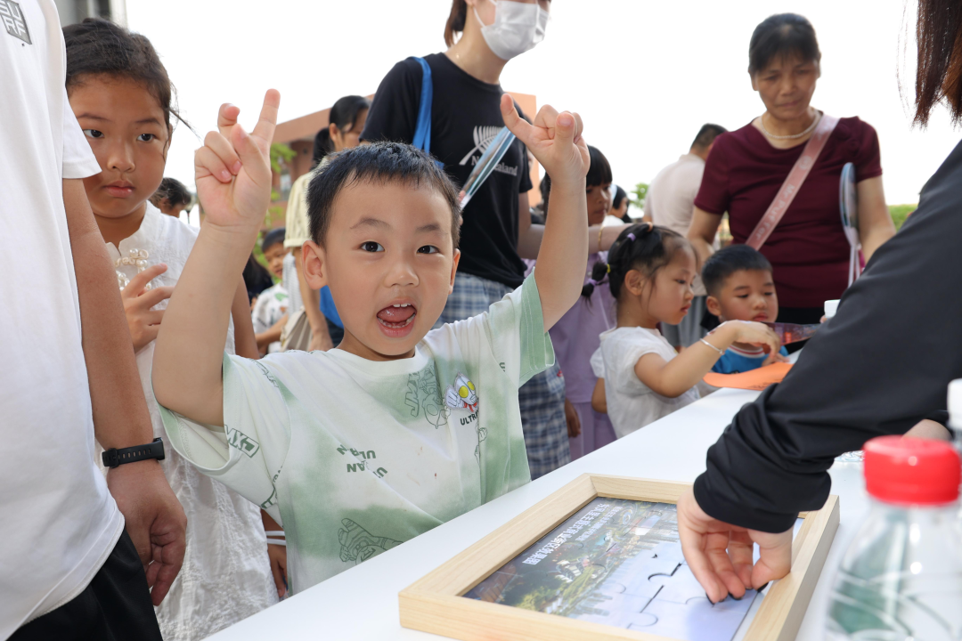 9孩子们通过“共绘东风”拼图感受城中村改造后的样子。通讯员供图